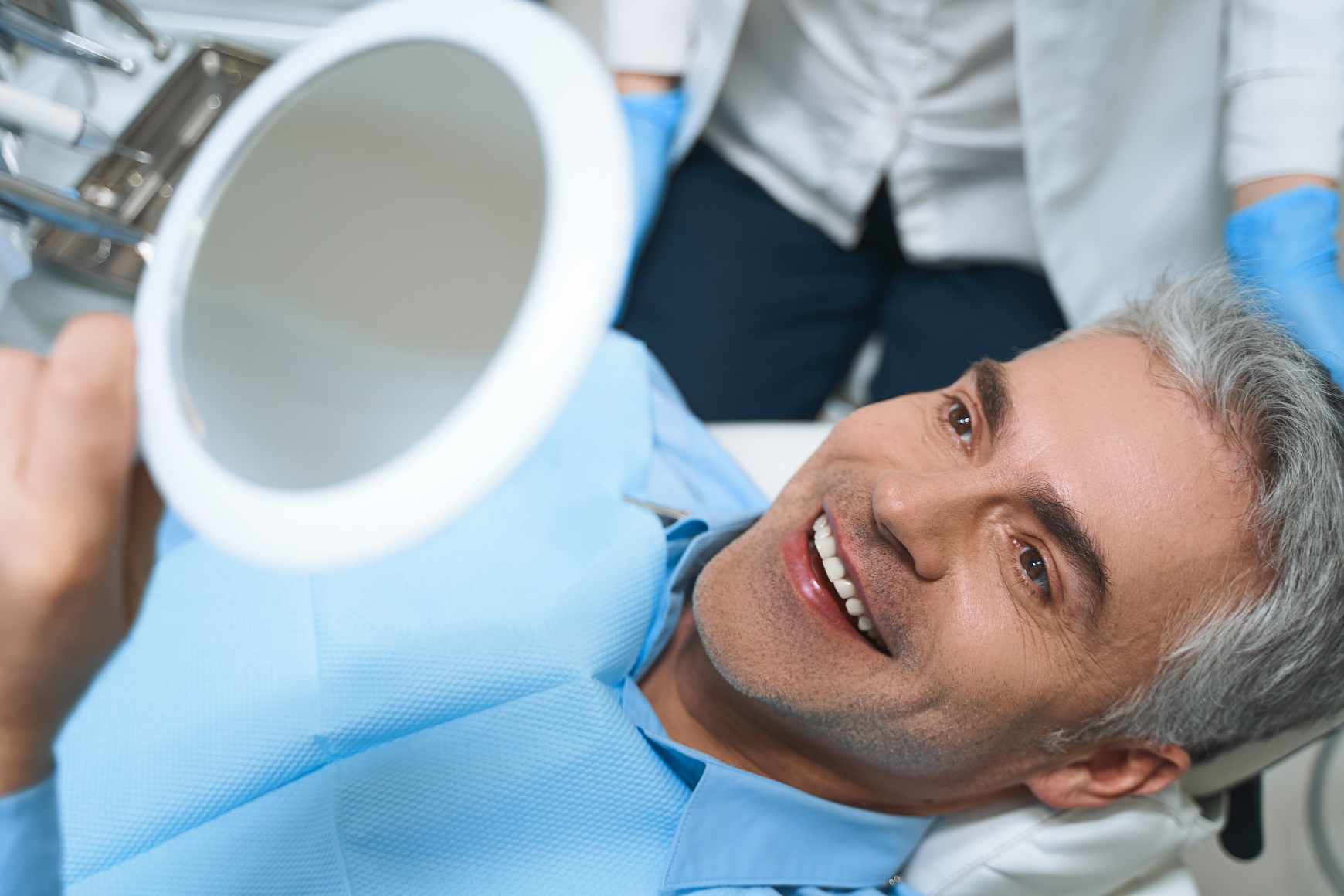 hombre-alegre-esta-acostado-en-una-silla-y-mirando-en-el-espejo-mientras-esta-encantado-con-el-trabajo-del-dentista