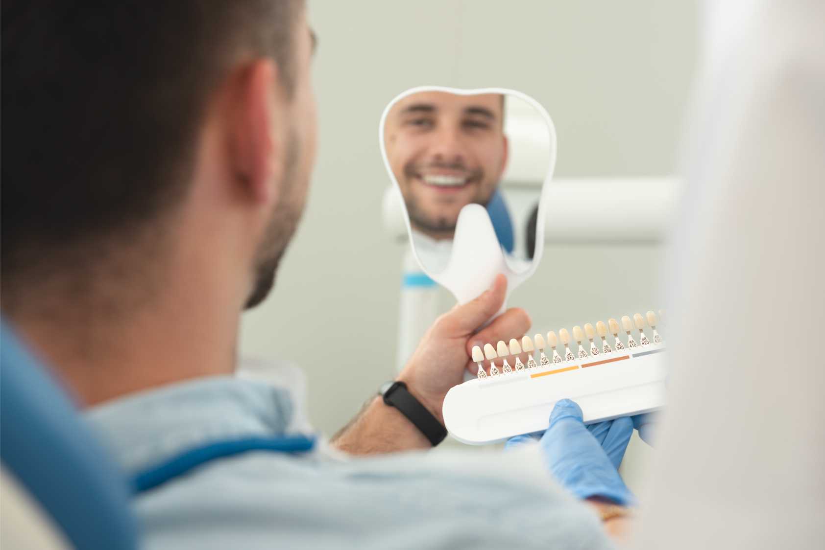 retrato-de-un-joven-sonriente-mirando-traves-del-espejo-en-una-clinica-dental